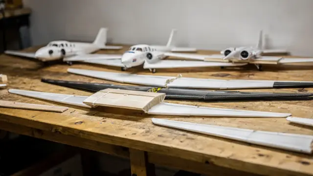 RC-Flugzeuge und Tragflächen auf einer Werkbank zum Vergleich der Spannweite