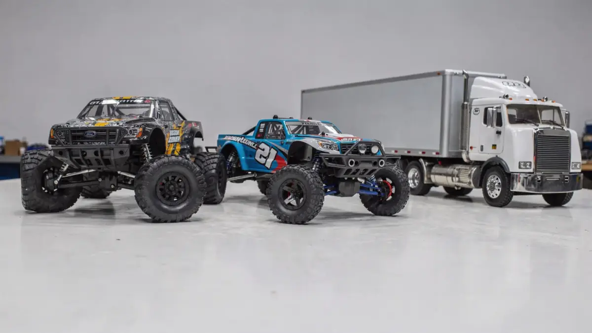 Verschiedene RC Truck Typen auf einem Tisch: Monster Truck, Crawler und andere Varianten im Vergleich.