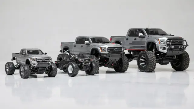 Mehrere RC Trucks in verschiedenen Maßstäben auf einem Tisch zur Veranschaulichung üblicher Größen.