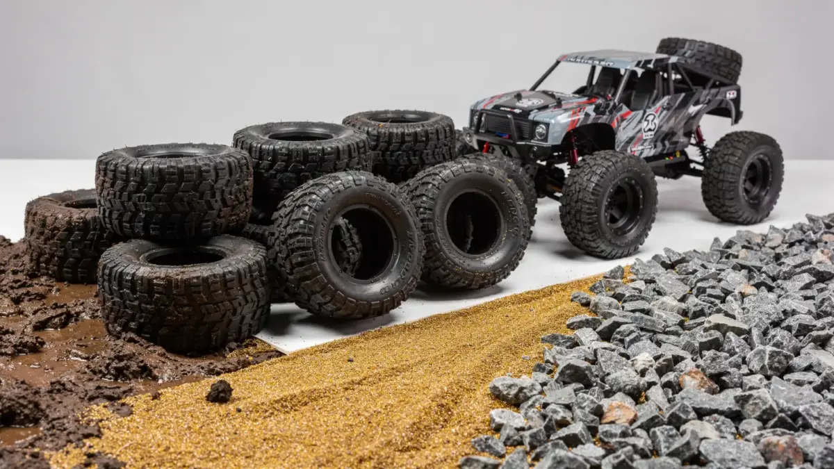 RC Truck Reifen neben einem Offroad-Modell auf Schlamm, Sand und Stein